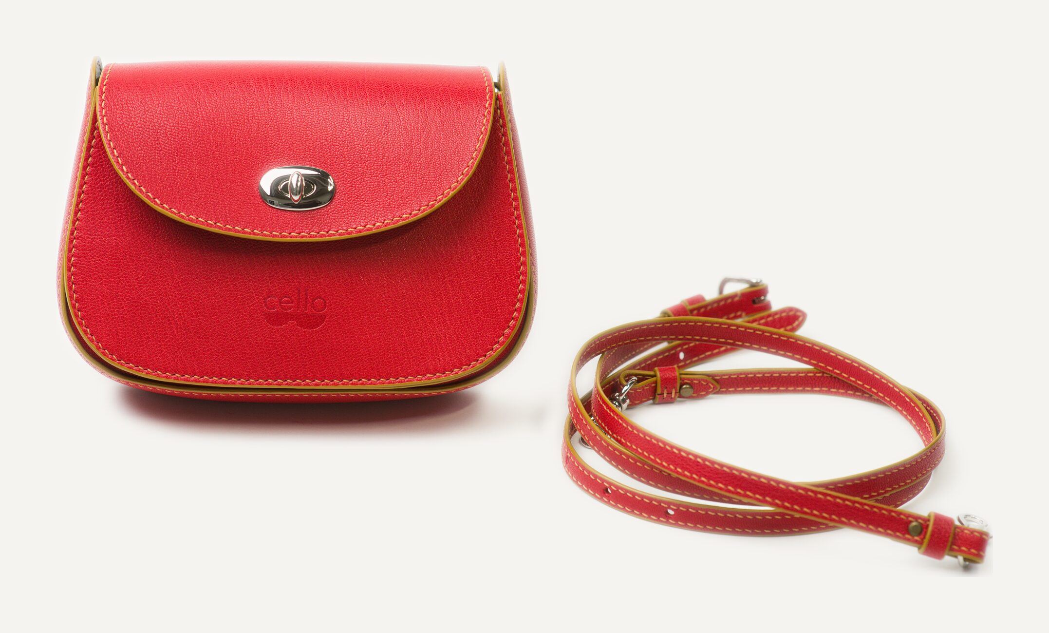 A bright red bag with ochre edges, its red strap coiled beside it