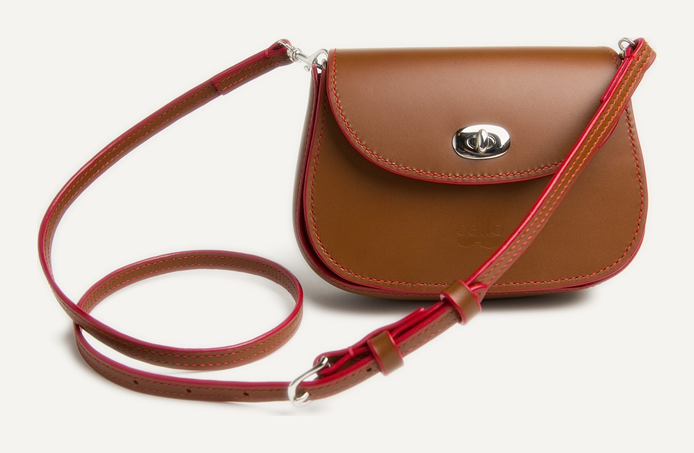 A tan bag edged and strapped in red